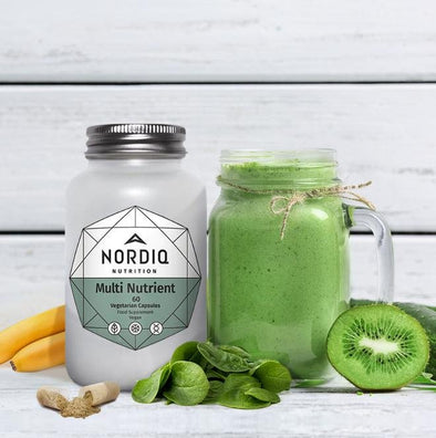 NORDIQ Nutrition Multi Nutrient bottle with green smoothie and kiwi, spinach leaves, banana, and open capsule.